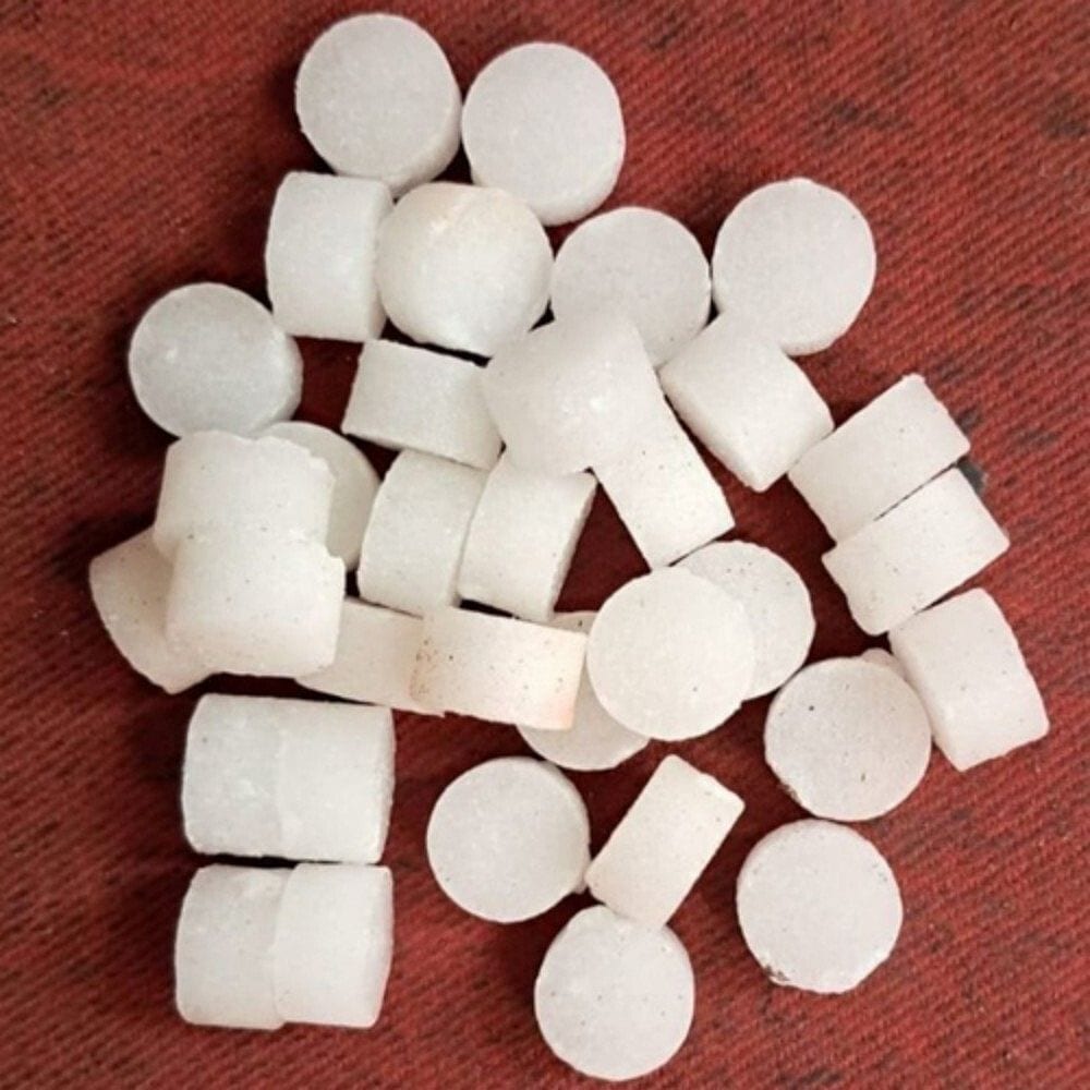 Round pressed V-BOSS camphor tablets scattered on a deep red cloth